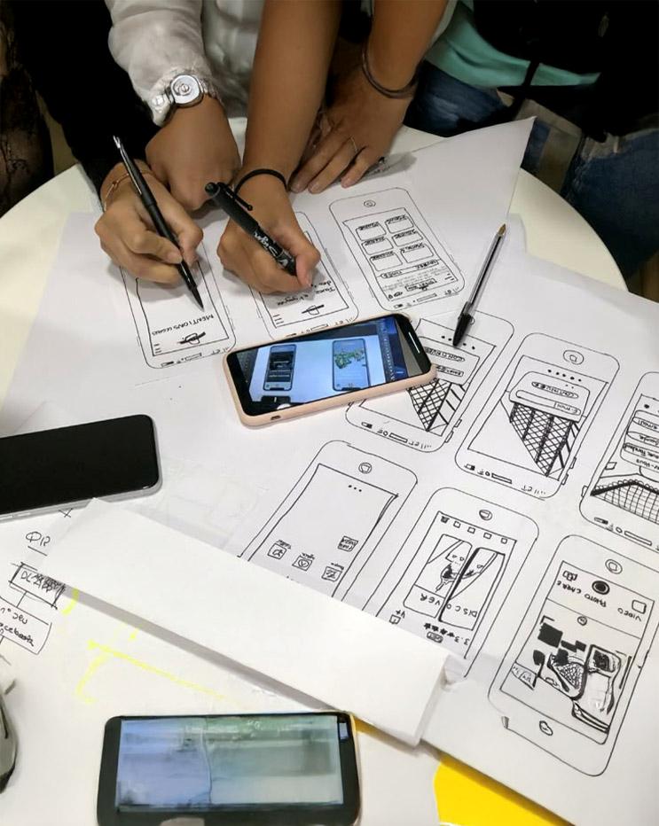 Mobile App Wireframing for UI UX UI UX wireframe planning session with mobile app sketches on paper.